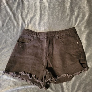 Svarta jeansshorts från Amisu - Snygga svarta jeansshorts från Amisu med fransiga kanter. Perfekta för en avslappnad stil. De har klassisk femficksdesign och knappgylf.