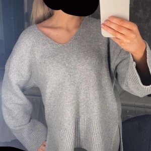 Grå stickad tröja från BikBok - Mysig grå stickad tröja från BikBok med v-ringning och långa ärmar. Perfekt för kyliga dagar med sin bekväma passform och ribbade detaljer vid ärmslut och nederkant, älskar den verkligen fortfarande men ska köpa lite nytt, den är lite nopprig men inget man tänker på som sagt väldigt fin  💕🥰 den ska vara lite overzised i modellen så den är bara mest väldigt mysig osv i storlek XS, Det är bara att köpa eller skicka vid fler bilder ❣️💕 så löser vi det på bästa sätt 🙏