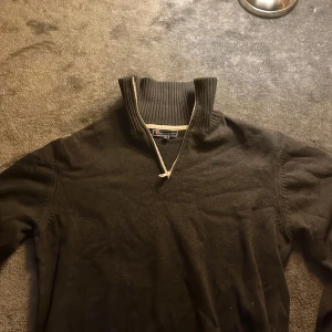 Svart tröja med dragkedja från Berkeley - Snygg svart tröja från Berkeley med dragkedja och hög krage. Perfekt för kyligare dagar med sin ribbade design vid kragen. Enkel och stilren, passar till många tillfällen.