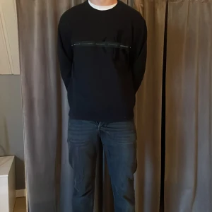 Svart tröja med dragkedja - Snygg svart tröja med en diskret dragkedja över bröstet. Perfekt för en stilren look. Tröjan har långa ärmar och en rund halsringning. Säljer pga för liten nypris - 500kr