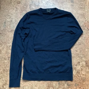 Mörkblå tröja i merinoull med v-ringning - Snygg mörkblå tröja med v-ringning och långa ärmar. Perfekt för kyligare dagar och enkel att matcha med olika outfits.