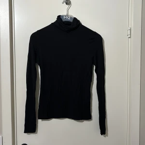 Svart polotröja från H&M - Säljer en stilren svart polotröja från H&M. Perfekt för kyligare dagar med sin långa ärmar och klassiska design. Passar utmärkt till både jeans och kjol. 🖤