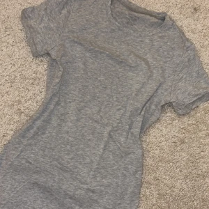 Grå t-shirt från Intimissimi - Säljer en enkel och stilren grå t-shirt från Intimissimi. T-shirten är kortärmad och tillverkad i mjukt material, säljer pga dubbletter❤️köpt för 500 kr därför priset!! Säljer även en i vit på min profil❤️🥰