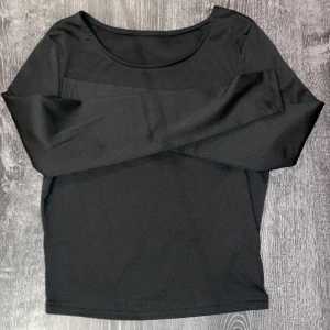 Svart långärmad topp - Snygg svart långärmad topp med rund halsringning. Perfekt för en stilren look och enkel att matcha med olika outfits.