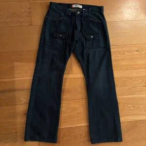 Vintage Levis jeans flared - Vintage mörkblå Levis jeans med fickor där fram och bak. Lätt bootcut/flare modell 32/30 