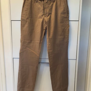 Beige chinos - Snygga beige chinos med normal passform och midwaist. Perfekta för en stilren look. Storlek 46