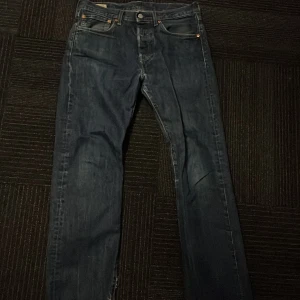 Levi's Premium Jeans 501 - Snygga Levi's Premium jeans i en klassisk blå färg. Dessa jeans har en straight passform och är tillverkade i slitstarkt denim. De har fem fickor och en knappgylf. Perfekta för en avslappnad stil. Syns lite nere vid benen att dessa är använda annars är de riktigt snygga. Nypris 800kr.  W31 L32