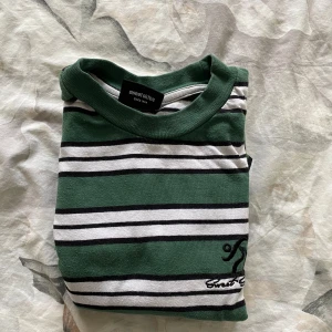 Grön och vit randig t-shirt från Sweetsktbs - Snygg grön och vit randig t-shirt från Sweetsktbs med broderad logga på bröstet. Perfekt för en avslappnad stil. Tillverkad i mjukt material för extra komfort.