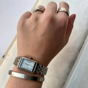 Silvrigt armband  - Stilrent silvrigt armband jag haft i år men aldrig använt, då jag tyckt det varit för stort för mig🥲 Inte jätteflexibel, men kan tryckas ihop till ca 6,3 cm och töjas till ish 8,5 cm☺️  Vet inte material och vet ej var ifrån jag fått det😔