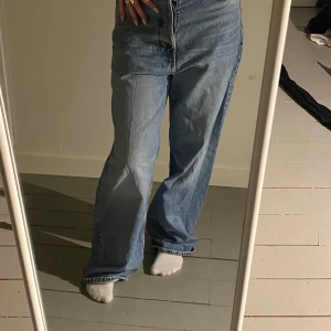 Blå jeans från weekday astro - Säljer ett par snygga blå jeans från wewkday. De har en hög midja och en avslappnad, wide fit. Perfekta för en casual look. Knappgylf och klassiska femficksdesignen gör dem både stiliga och praktiska. Lite slitage vid fötterna på bakre sidan eftersom att dem är för långa för mig.  Storlek 25,32
