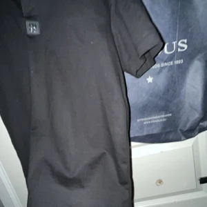 Svart kortärmad piké från Hugo - Snygg svart piké från Hugo med korta ärmar och en diskret logga på bröstet. Perfekt för en stilren look.