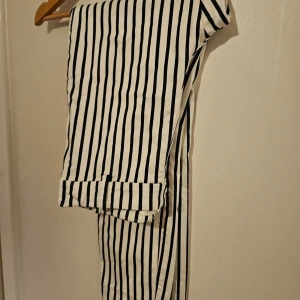 Randiga byxor från H&M - Snygga svart- och vitrandiga byxor från H&M. De har en klassisk design med raka ben och en bekväm passform. Perfekta för en stilren look.