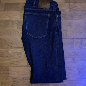 Mörkblå jeans från Paul Smith - Snygga mörkblå jeans från Paul Smith med klassisk femficksdesign. Jeansen har en läderpatch med logotyp baktill. Perfekta för en stilren look.