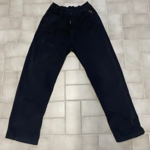 Svarta byxor från Sweet SKTBS - Snygga svarta byxor från Sweet SKTBS med en cool broderad detalj av en figur. Byxorna har en loose passform och är perfekta för en avslappnad stil. Tillverkade i Turkiet med skandinavisk design.