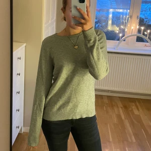Grön stickad tröja från Vila - Mysig grön stickad tröja från Vila med rund halsringning och långa ärmar. Den är i storlek M, men passar även de som har xs och s. Sparsamt användande och säljer då den inte kommer till användning 