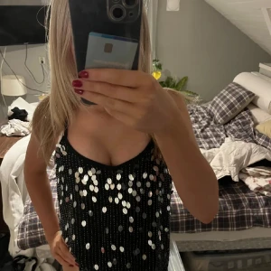 fest topp - Svart topp med silvriga paljetter på. Den har ett lite genomskinligt tyg i ryggen! Storlek XS, knappt använd