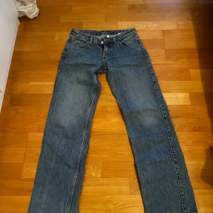 Lågmidjade jeans från Weekday - Snygga blå lågmidjade jeans från Weekday i modellen arrowmed. De har en rak passform och är perfekta för en avslappnad stil. Tillverkade i slitstarkt denim.