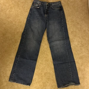 Blå jeans  - Säljer ett par klassiska blå jeans från Ginatricot. De har en rak passform och är tillverkade i slitstarkt denim. Perfekta för en avslappnad stil.