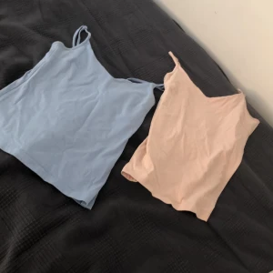 Två linnen från 157 i blått och beige - Säljer två snygga linnen från 157 i storlek M. Det ena är i en ljusblå färg och det andra i Rosa. Perfekta för sommaren med sin sköna bomullskvalitet och lite stretch tack vare elastan. De är ärmlösa och har en tight passform, vilket gör dem superbek