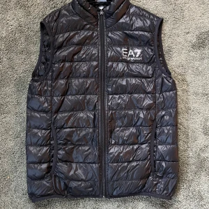 EA7 väst  - Hej säljer en EA7 väst som är perfekt nu när hösten börjar komma västen är i bra skick inga hål eller slitningar, västen sitter mer som S än M hör av er vid frågor eller fler bilder