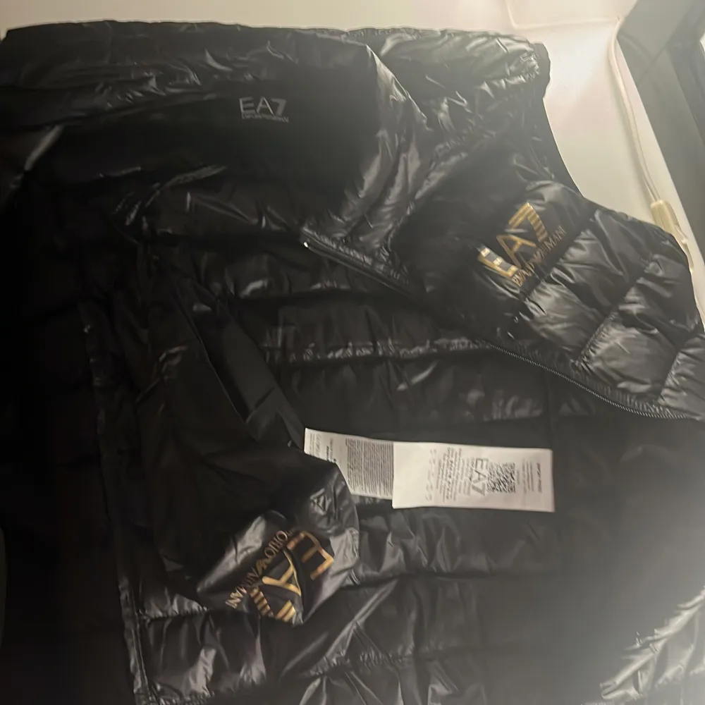 Säljer nu min emporio Armani dunväst då den är för liten. Väldigt fint skick, köpt på Zalando. Nypris 1999kr. Tillkommer en bag som man kan fästa på insidan av västen (bild 3). 2 fickor på utsidan och en på vänster insida.. Takit.