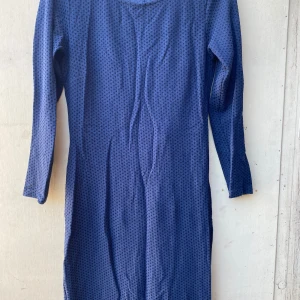 Mörkblå klänning från Vila - Säljer en snygg mörkblå klänning från Vila. Den har ett diskret prickigt mönster och är långärmad, perfekt för både vardag och fest. Klänningen är i storlek L och har en bekväm passform.