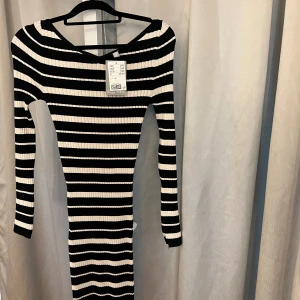 Vit/ svart randig tunn stickad klänning  -  Svart vit tunn stickad klänning som aldrig är använd (prislappen är kvar) Fin detalj vid ärmarna (slits) Toppen inför hösten.   • Storlek Xs men passar en S