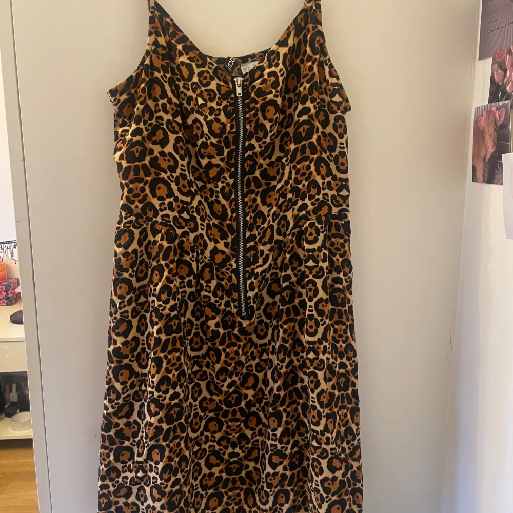 Säljer en supercool leopardmönstrad klänning från H&M. Den har en dragkedja framtill och är ärmlös, vilket gör den perfekt för en fest eller en utekväll. Klänningen är i storlek 38 och har en normal passform. Materialet känns lätt och bekvämt, perfekt för att dansa hela natten! 🐆✨. Klänningar.