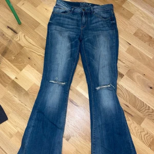 Blå bootcut jeans från ONLY - Säljer ett par blå bootcut jeans från ONLY. De är low waist och har hål vid knäna. Det är i storlek 29 som motsvarar S/M, de passar mig som har M på jeans. Inga defekter💙