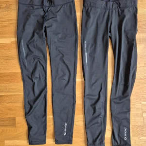 Träningsbyxor 2st Soc - Träningsbyxor från Soc. Använd några gånger. Stechbar och ej genomskinliga. Rätt tjock och bra material. Dragkedja på vardera sida vid benen. Dragkedja på höften. Snören på insidan för att dra åt. 90% polyester, 10% elastan.  1 st för 35 2 st för 50