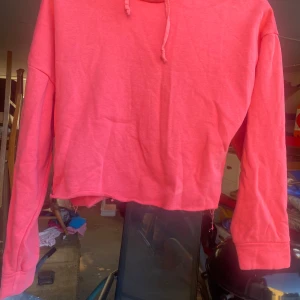 Rosa croppad hoodie - Säljer en superfin rosa croppad hoodie från lager 157. Den har en skön luva och långa ärmar, perfekt för en avslappnad stil. Passar perfekt till både jeans och leggings. Perfekt för höst och vår!