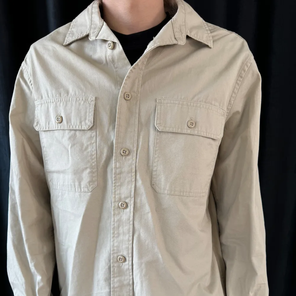 Säljer en stilren beige overshirt från H&M i storlek M. Skjortan har långa ärmar och två bröstfickor med knappar. Pris kan diskuteras hör av dig vid frågor.. Jackor.