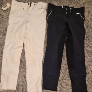 Ridbyxor - Två ridbyxor. Vita från hansbo och blå från crw. Vita har lappen kvar. 140 i båda
