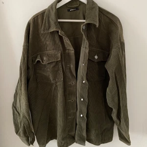 Grön jacka  - En vanlig stripad tunn jacka från Gina tricot:) kan enkelt slängas över en snygg outfit eller ha som en enklare vardags jacka🫣 OBS!! Ena knappen på bröstfickan har ramlat av😬