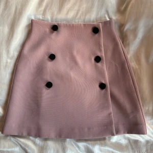 Rosa minikjol med knappar  - Asos, storlek S men psssar som XS