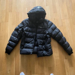 Sail racing puffer jacka - Svart sail racing puffer jacka, använd under 1 vinter, jävligt varm och mjuk, garanti på att du inte kommer att frysa. Nypriset på denna jacka är 4,200kr, ni kan kolla själva på google, sök på ”W Cloud Down Hood”