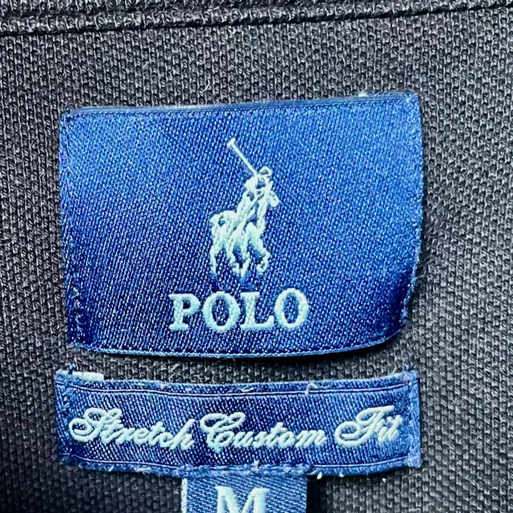 Säljer en klassisk svart pikétröja från Polo Ralph Lauren. Den har en broderad vit logga på bröstet och är i storlek M. Perfekt för en stilren och avslappnad look. Tröjan är i bra skick och redo för nya äventyr!. Tröjor & Koftor.