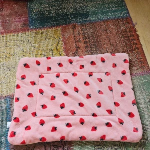 Rosa filt med jordgubbsmönster - En supermjuk och mysig rosa djursäng med ett gulligt jordgubbsmönster. Perfekt för att göra det extra bekvämt och stiligt hemma. Passar bra som dekoration eller för att hålla sig varm under kalla dagar.