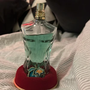 Jean Paul Gaultier Le Beau Paradise Garden - Säljer en Jean Paul Gaultier Le Beau Eau de Parfum i en unik flaska formad som en manlig torso. Parfymen har en fräsch och förförisk doft, perfekt för den som vill sticka ut. Flaskan är 75 ml och kommer i en dekorativ förpackning med tropiskt tema.