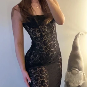Svart spetsklänning - Elegant svart klänning med spetsdetaljer och tight passform. Perfekt för en kväll ute eller en speciell tillställning. ”Tjockare” / mer täckande spets över bysten. Går bra att ha beigea eller svarta underkläder beroende på vilken look man vill gå för. Aldrig använd, endast testad