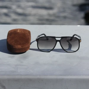 Tom ford Solglasögon  - Tom Ford Raoul solglasögon, Made in Italy. Storlek L, glasbredd 62 mm, näsbrygga 14 mm och skalmlängd 140 mm. Nästan ny, säljs med originalbox, fodral och certifikat. Inköpta via auktoriserad återförsäljare, nypris ca 4200 kr. Klassisk design, perfekt för både festliga och avslappnade vår- och sommaroutfits. Spårbar frakt inom 1-2 arbetsdagar. Referenser finns vid förfrågan.