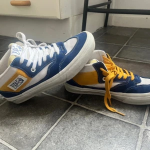 Van Half Cab - Snygga sneakers från Half Cab i en fräsch kombination av blått, gult och vitt. Skorna har en klassisk design med snörning och en bekväm sula. Perfekta för en avslappnad stil. Storleken är 38 och är relativt icke använda, ställ gärna frågor!