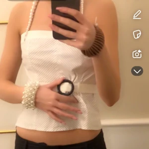 Festtopp - Säljer min favorit topp som är vit och blå randig och axelbandslös. Midjan går att justera och den är perfekt till en fest eller middag! Slutsåld!