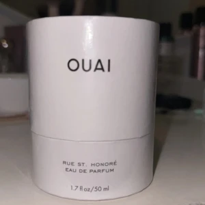 OUAI Rue St. Honoré Eau de Parfum - OUAI Rue St. Honoré Eau de Parfum är en sofistikerad och feminin doft med blommiga toner. Den kombinerar förföriska noter av gardenia, viol, ylang-ylang och vit mysk. Flaskan är stilren och modern med en vit kork och genomskinligt glas.