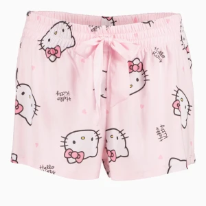 Rosa Hello Kitty shorts - Söta rosa shorts med Hello Kitty-motiv och små hjärtan.  Använda fåtal gånger. Pris i affär är 159. Från New Yorker. Dom har ett litet hål därför priset. Om intresse skickar jag fler bilder