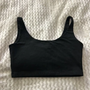 Svart ärmlös linnetopp - Snygg och enkel svart ärmlös linnetopp. Perfekt för lager-på-lager eller att bära som den är. Mjuk och bekväm passform.