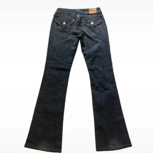 True religion bootcut jeans - Snygga mörkblå true religion bootcut jeans med låg midja. Mått midja 34cm.