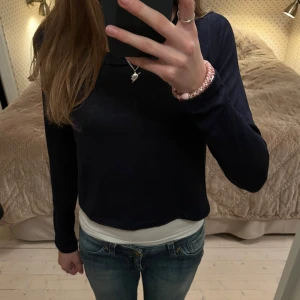 Mörkblå långärmad tröja  - Säljer en jättefin mörkblå långärmad tröja från Gina Tricot. Säljer eftersom jag har för mycket kläder! Den är superfin med ett linne under då den är kort! Pris kan diskuteras