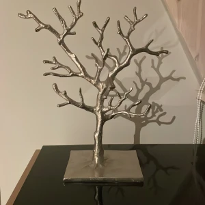 Smyckesträd i silverfärg - Elegant smyckesträd i silverfärg, perfekt för att organisera och visa upp dina smycken. Trädet har en stilren design med många grenar för att hänga halsband, armband och ringar. En snygg och praktisk inredningsdetalj för ditt rum. Köpt för 800. men jag använder den inte längre därför säljer jag den för jag vill bli av med den 💗💗