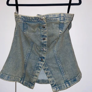 Denim-topp från H&M - Trendig denim-topp från H&M med knappar framtill och en insydd form (Inga band).✨